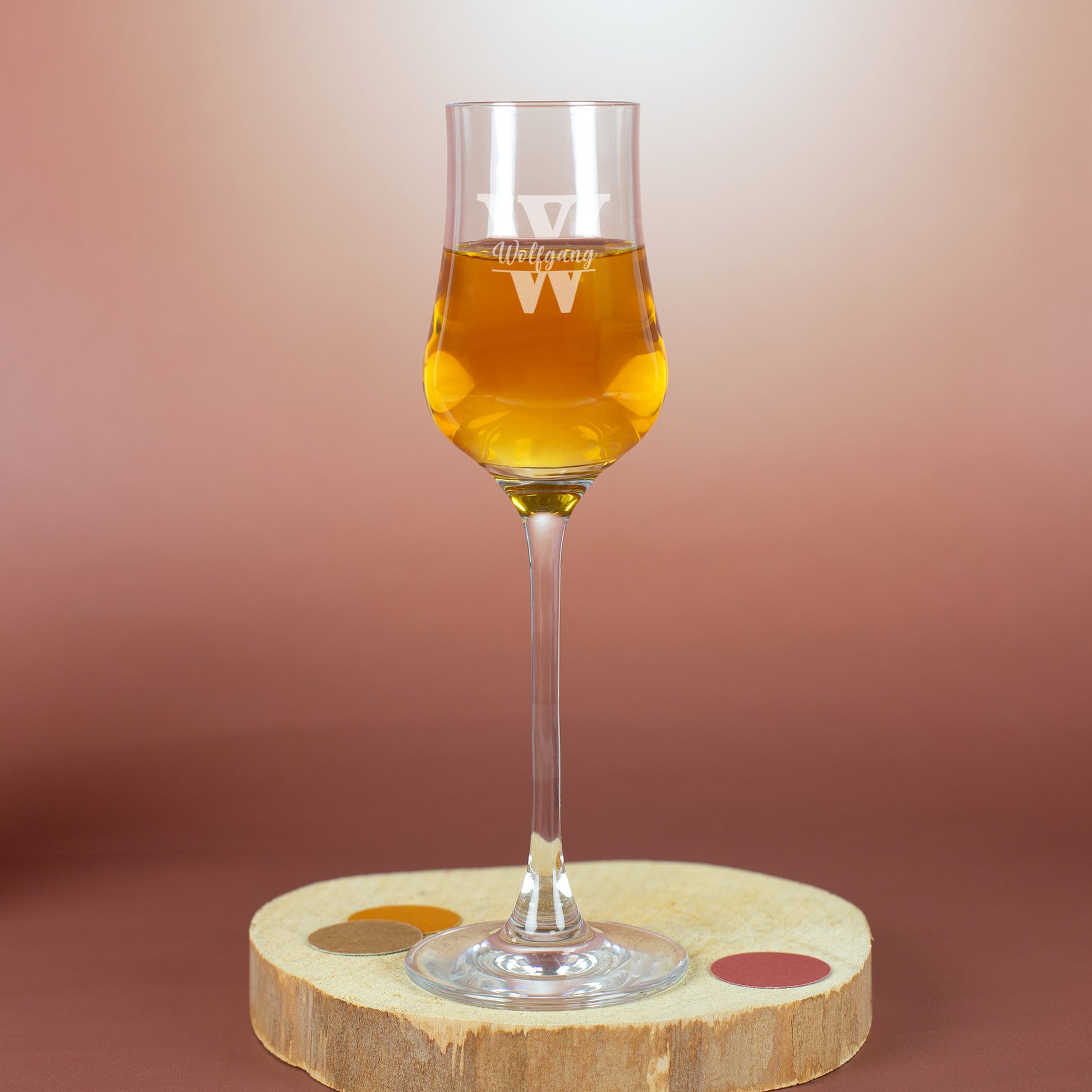 Leonardo Grappaglas mit Gravur „Wolfgang“ und Initiale W – auf Holzscheibe mit warmem Hintergrund.