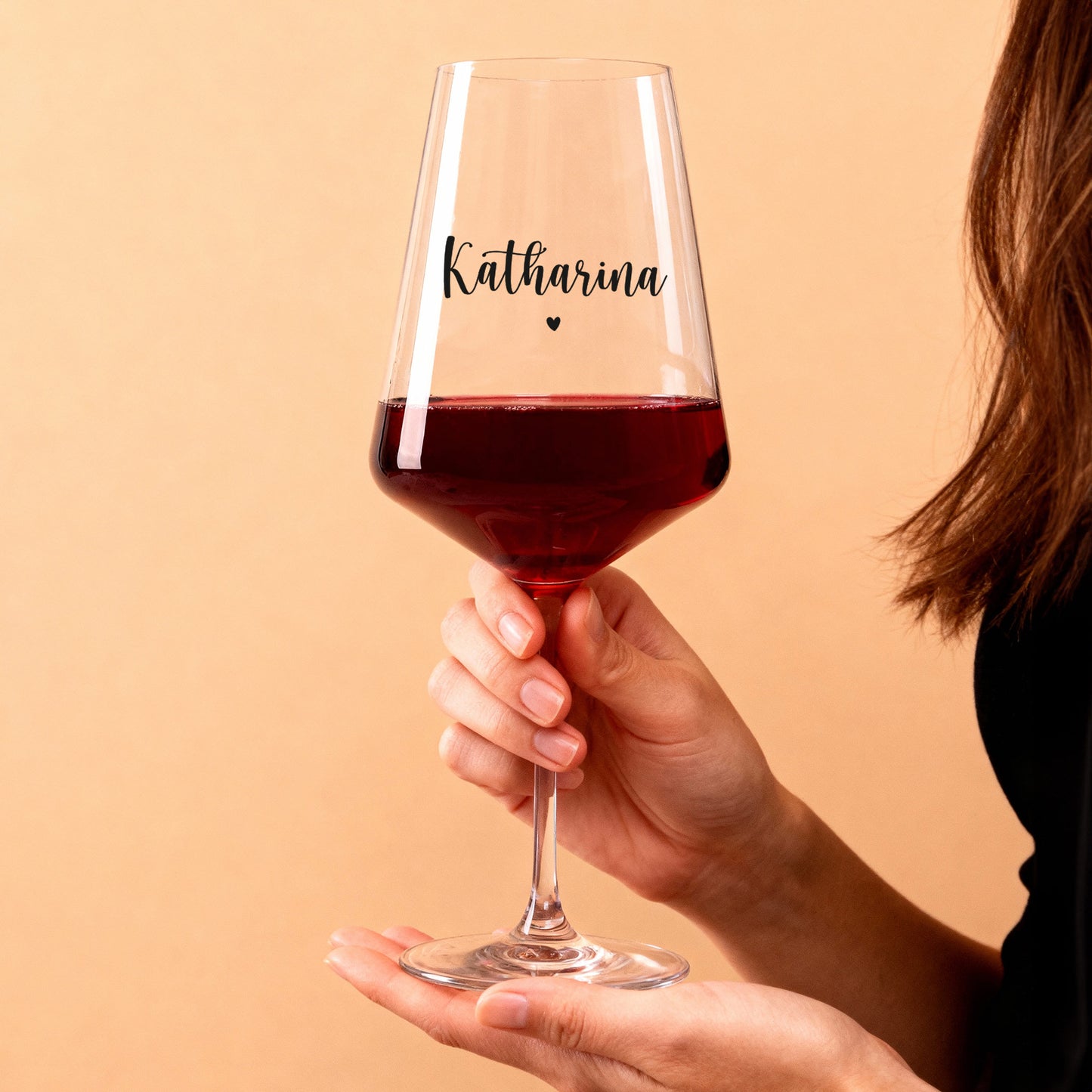 Personalisiertes Weinglas mit Name Katharina und Herzmotiv, in der Hand gehalten