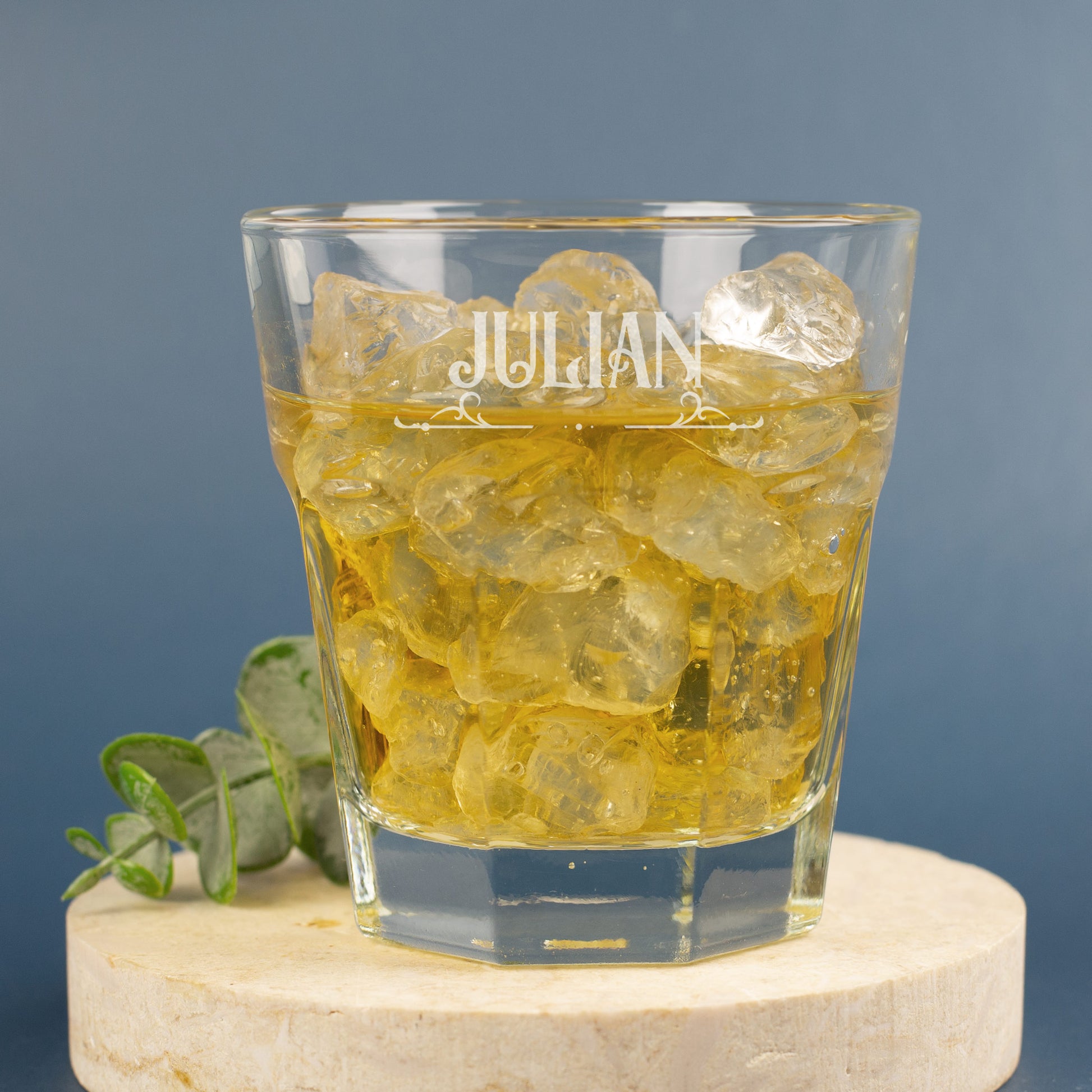 Graviertes Leonardo-Trinkglas mit feinem Ornamentmotiv und Namensschrift, dekoriert mit Eukalyptus auf hellem Stein