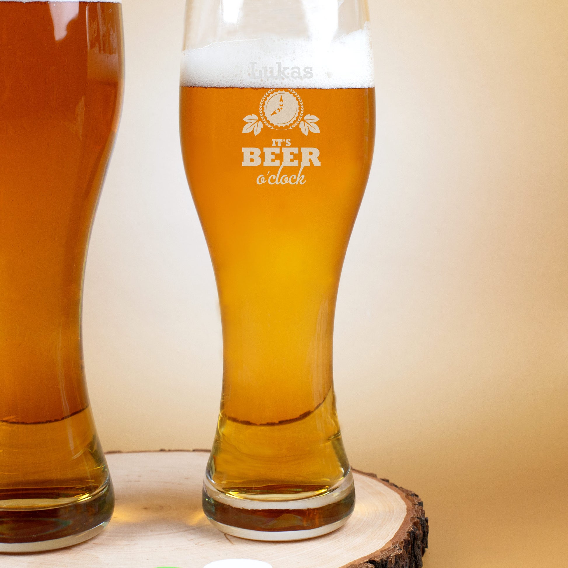 Graviertes Weizenglas mit Bierfüllung und Name „Lukas“, Motiv „It’s Beer o’clock“ – Produktaufnahme auf Holzunterlage