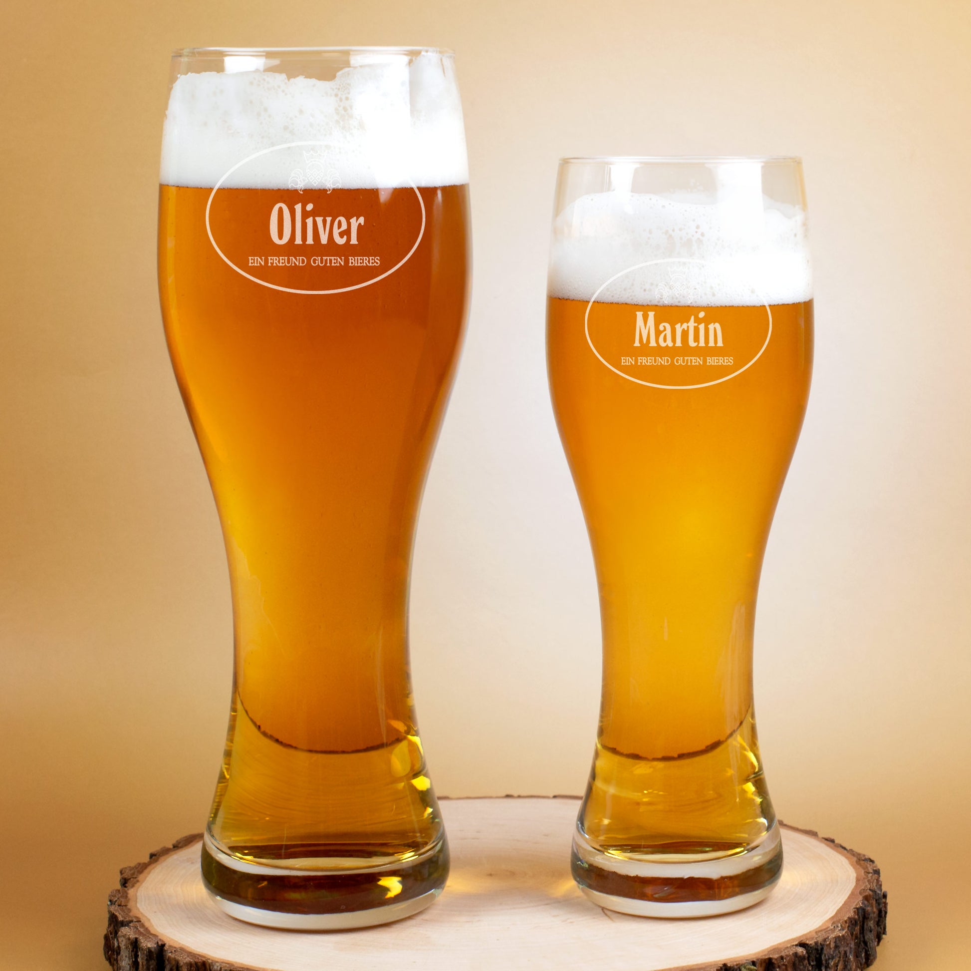 Zwei gravierte Weizengläser mit Bier, Namen Oliver und Martin, auf Holzpodest