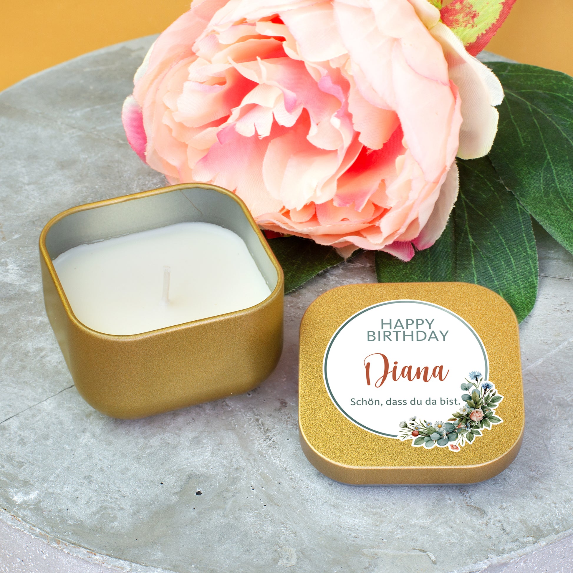 Goldene Mini Duftkerze mit Happy-Birthday-Motiv und Personalisierung Diana neben Blume