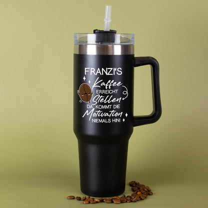 Thermobecher in Schwarz mit Kaffee-Spruch und Name vor grünem Hintergrund mit Kaffeebohnen dekoriert