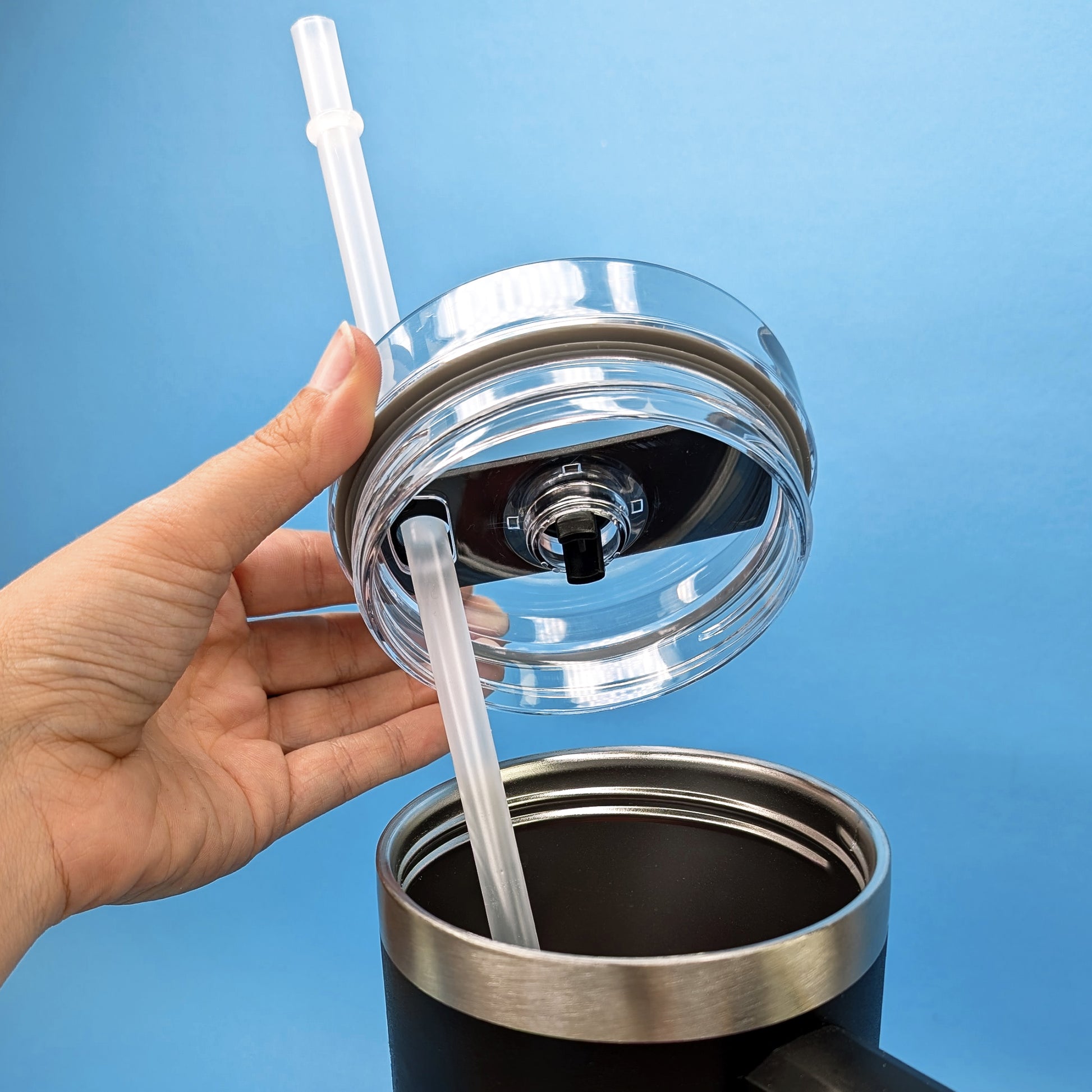 Becher mit eingesetztem Strohhalm und offenem Deckel