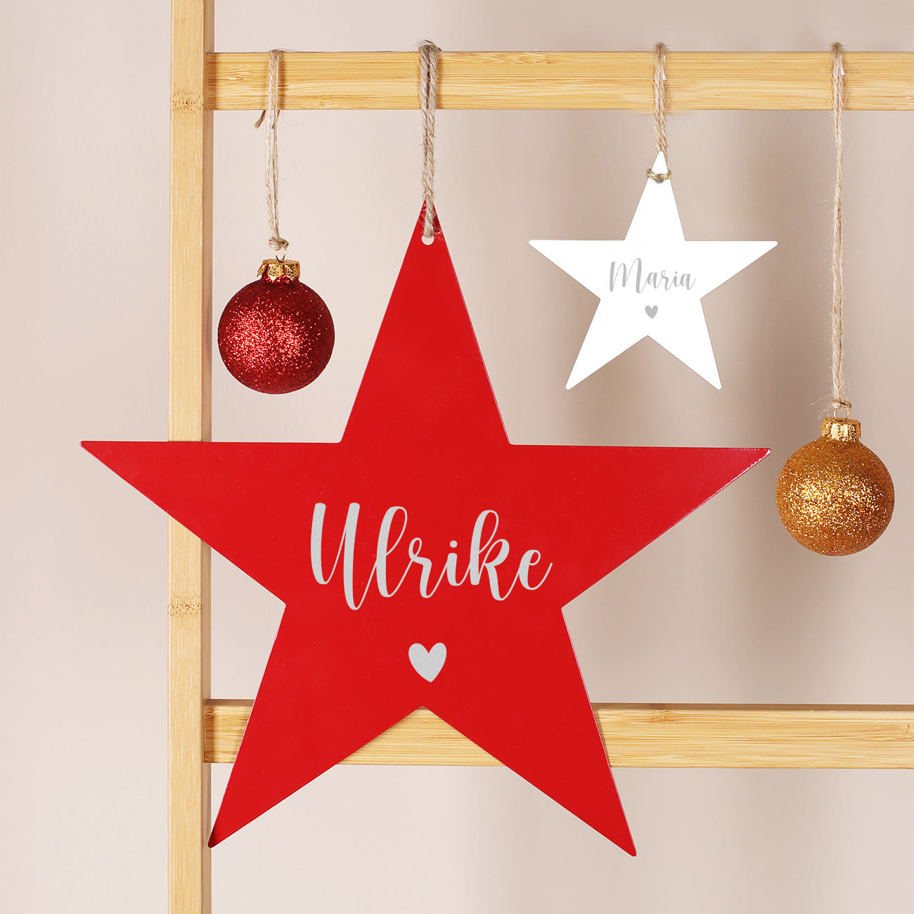 Weiße und rote Metallsterne mit Namensgravur in zwei Größen