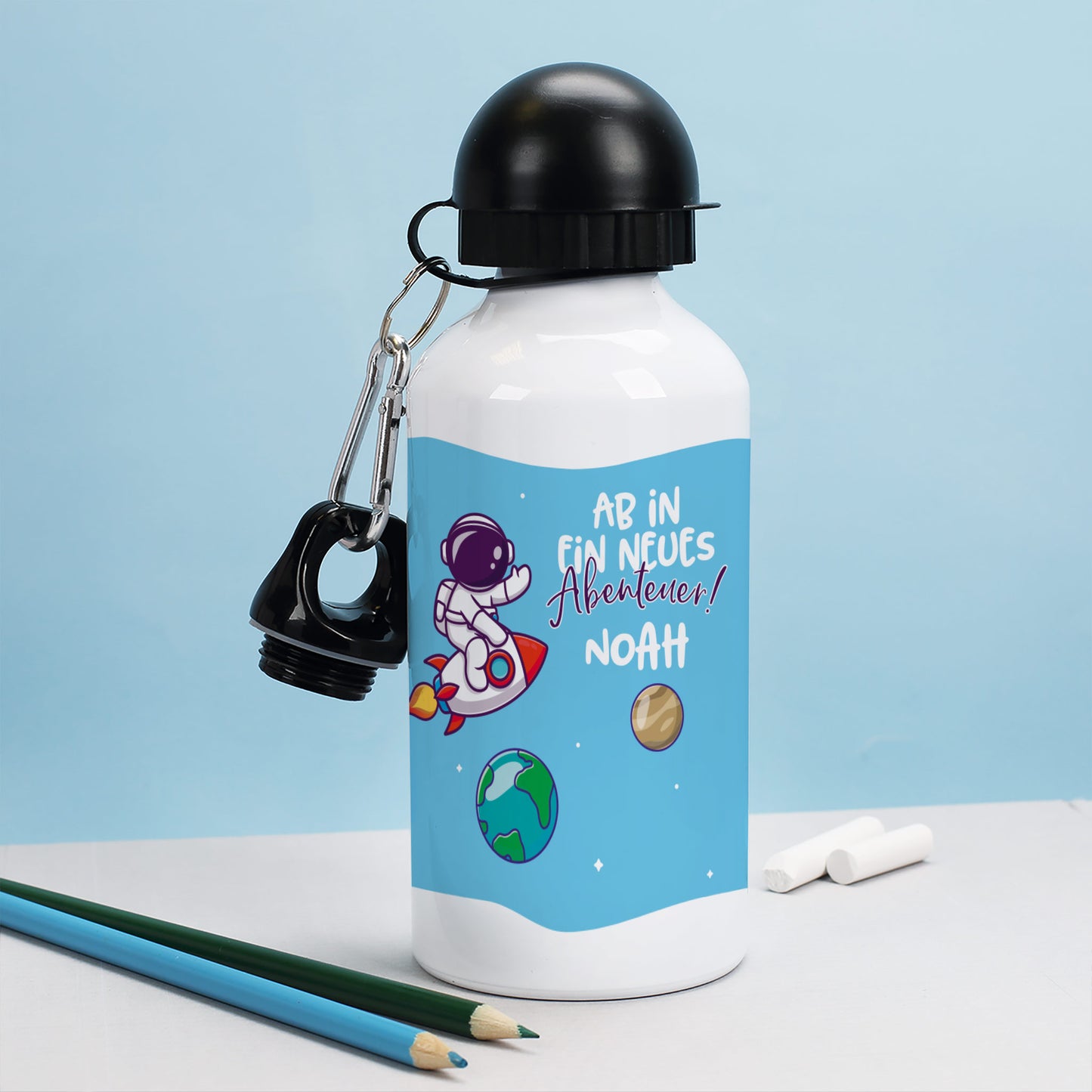 Kinder-Trinkflasche mit Astronautenmotiv und Name auf Schreibtisch – ideal für Einschulung oder Kindergartenstart