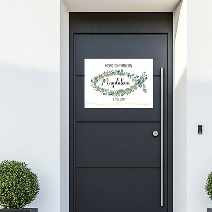 Poster-Banner an einer Haustür mit dem Text „Meine Konfirmation“, Name „Magdalena“ und Datum „2. Mai 2027“. Das christliche Motiv besteht aus Eukalyptuszweigen in Fischform.