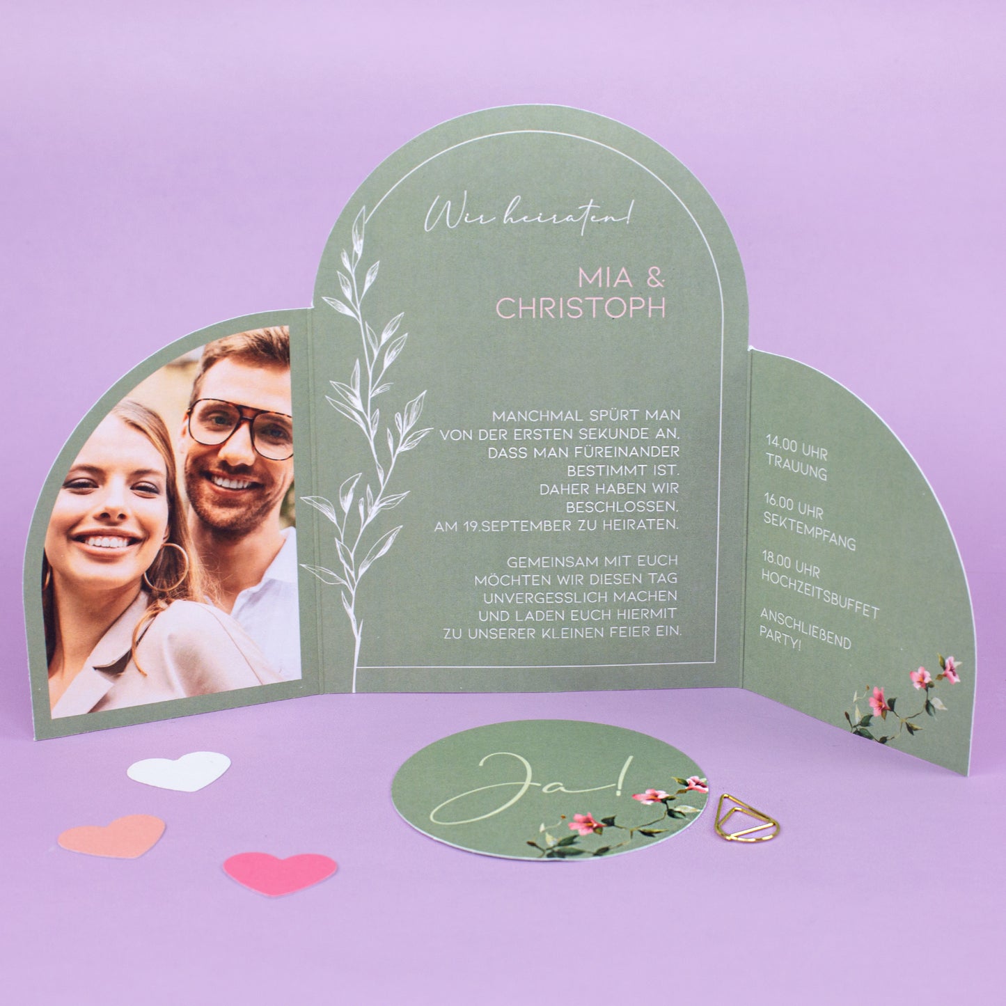 Geöffnete Hochzeitskarte mit Ja Karte, personalisiertem Einladungstext, floralen Elementen und goldener Klammer
