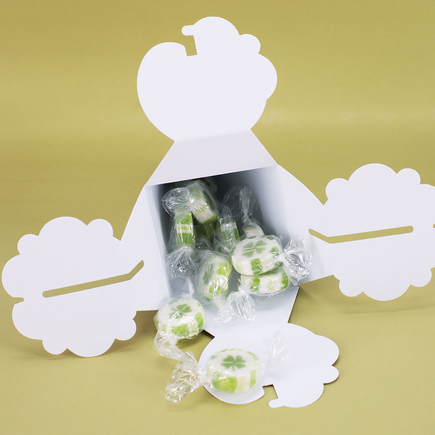 Mini-Schultüte geöffnet mit sichtbaren Bonbons in grünem Kleeblattdesign
