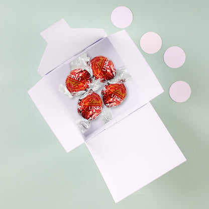 Komplettes Geschenkset mit Pappbox, darin vier Lindorkugeln in roter Folie  – ideal als liebevolle Aufmerksamkeit.