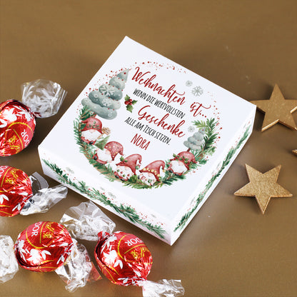 Geöffnete Geschenkbox mit Wichtelmotiv, Name und vier Lindor-Kugeln.