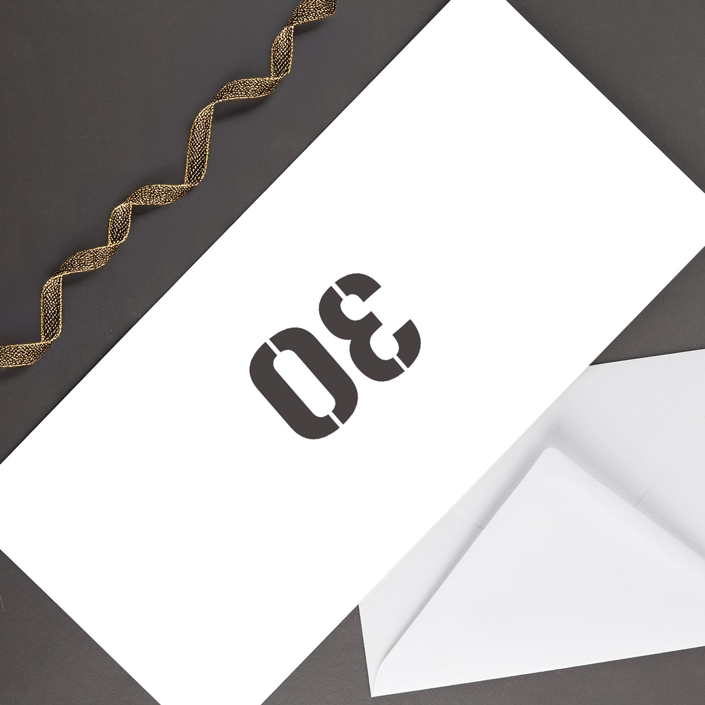 Rückseite der Geburtstagskarte mit großer 30 auf weißem Briefumschlag, dekoriert mit goldenem Geschenkband auf dunklem Untergrund