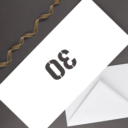 Rückseite der Geburtstagskarte mit großer 30 auf weißem Briefumschlag, dekoriert mit goldenem Geschenkband auf dunklem Untergrund