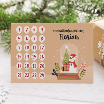 DIY-Adventskalender-Klappkarte mit Schneemann, Geschenken und Name „Florian“ auf dem Tisch