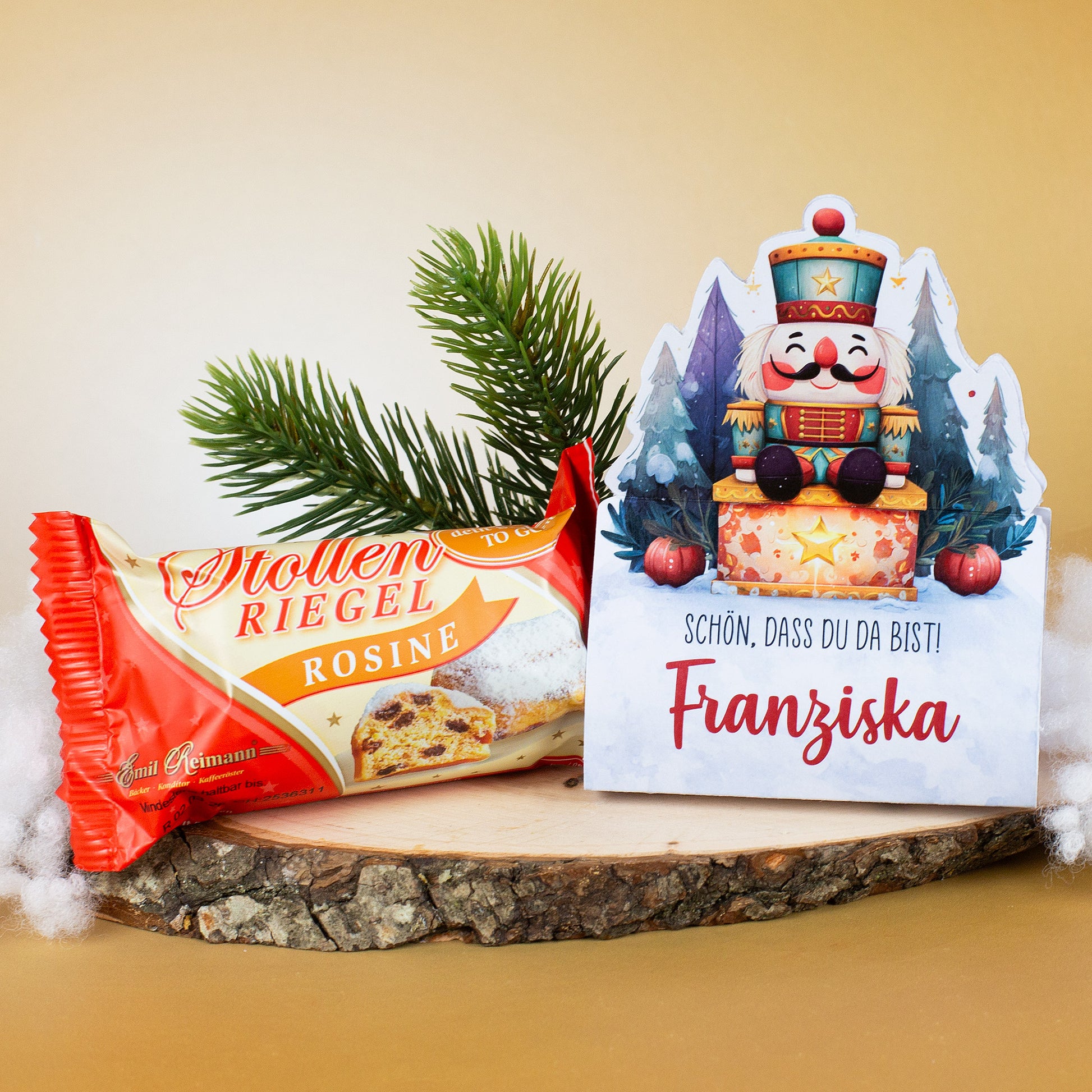Nussknacker-Stollenverpackung „Franziska“ mit Stollenriegel und Tannenzweig auf Holzplatte