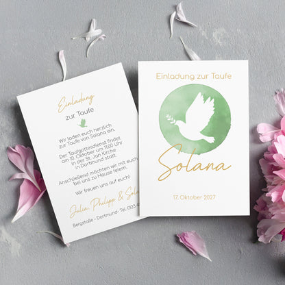 Elegante Einladungskarte zur Taufe mit einem sanften, modernen Design. Die Vorderseite zeigt eine weiße Taube mit Olivenzweig in einem grünen Aquarell-Kreis, symbolisch für Frieden und Segen. Der Name "Solana" ist in goldener Schreibschrift darunter platziert, ergänzt durch den Schriftzug "Einladung zur Taufe" und das Taufdatum „17. Oktober 2027“. Die Rückseite enthält den Einladungstext mit Details zur Tauffeier, gedruckt in einer stilvollen Mischung aus Serif- und Handschriftfonts. Die Karten liegen auf e