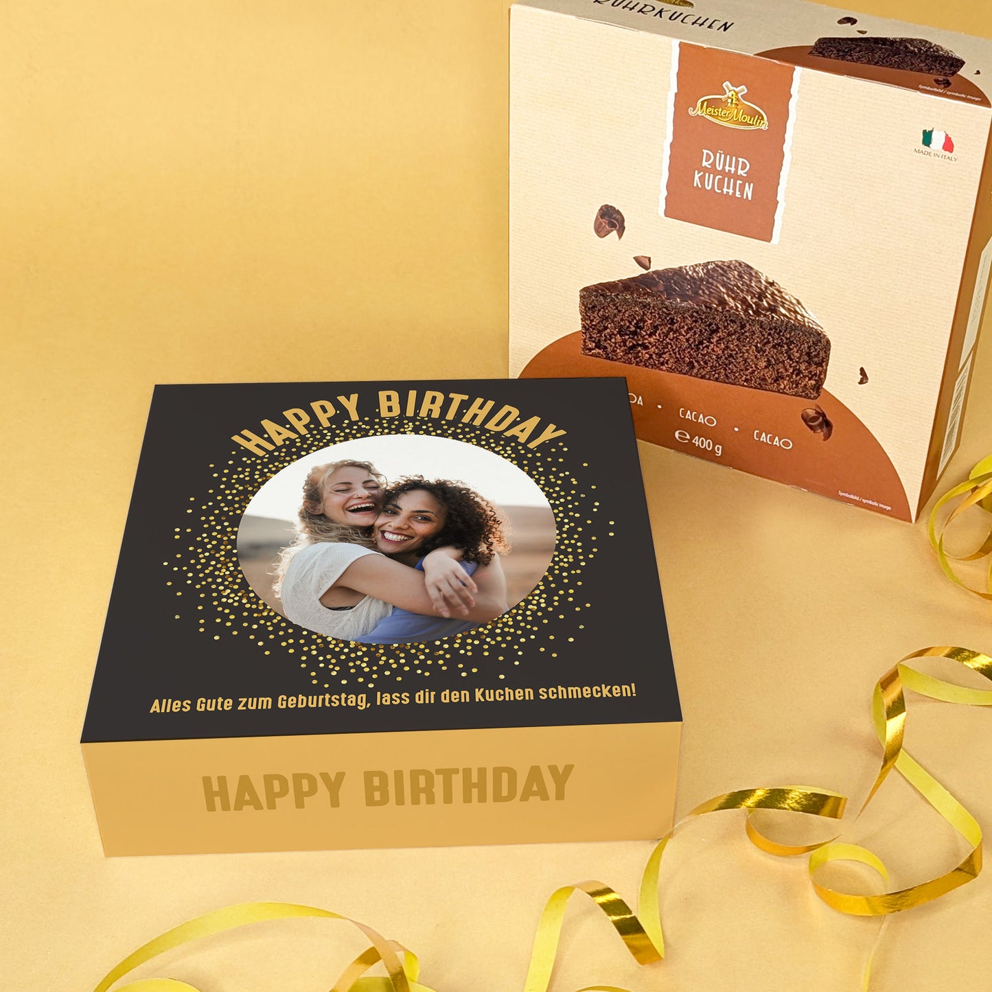 Personalisiertes Geburtstagskuchen-Geschenk mit Foto auf schwarzer Verpackung und Schokokuchen daneben