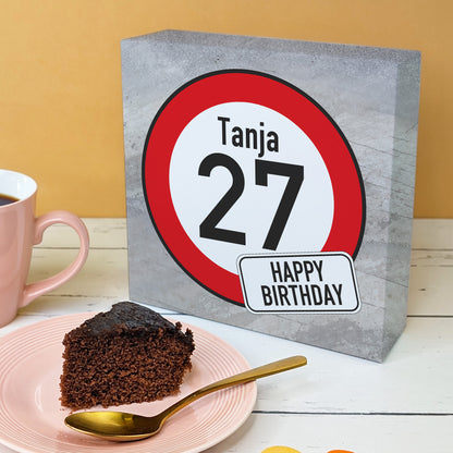 Geburtstagskuchenbox mit Verkehrszeichen „27“ und Name Tanja, stehend auf Tisch mit Kuchenteller und Kaffeetasse