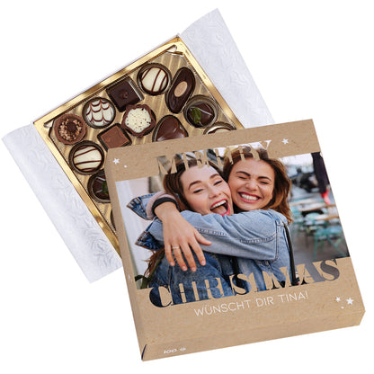 Geöffnete Lindt Pralinenbox Merry Christmas mit goldener Innenschale und personalisiertem Deckel.