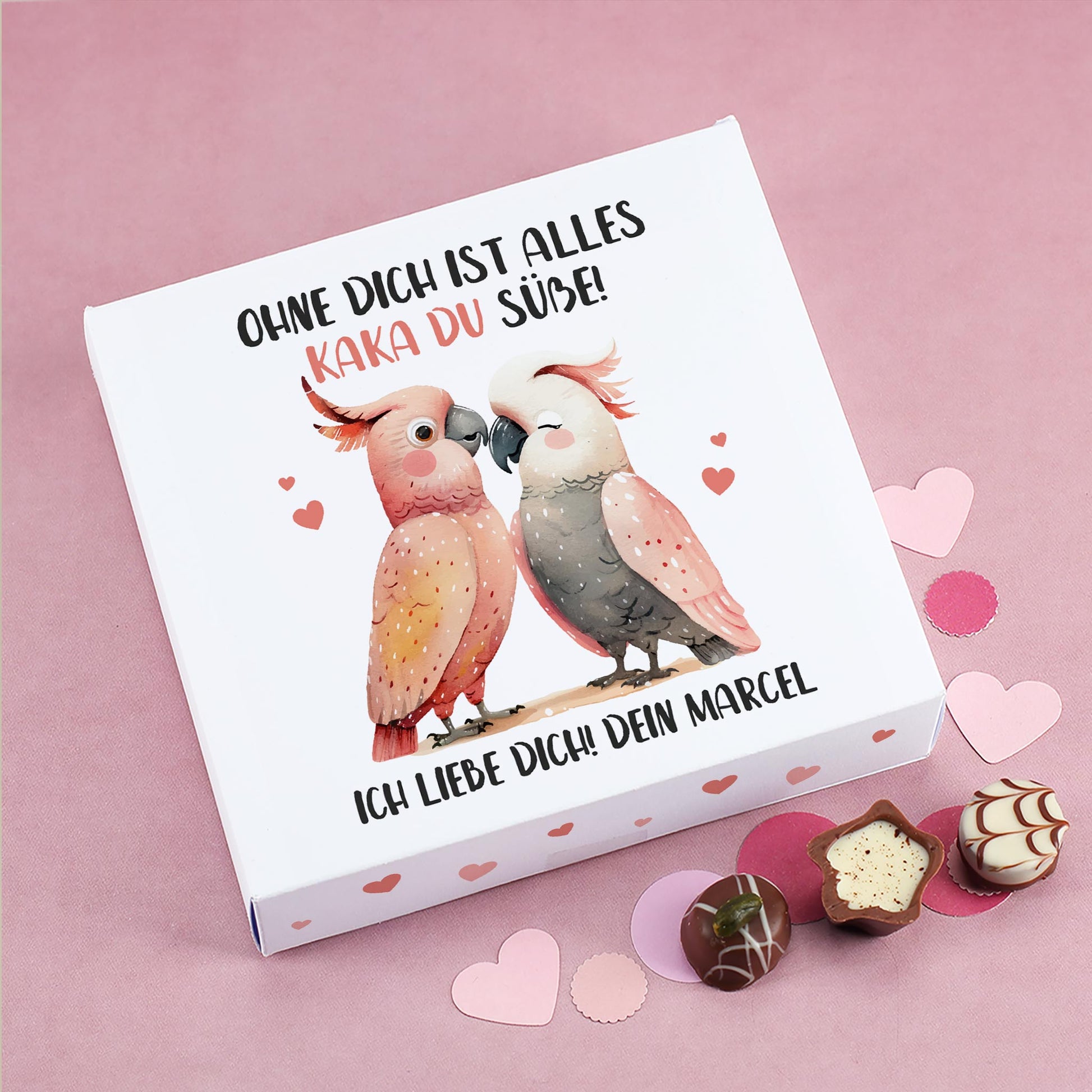 Personalisierte Lindt Pralinenbox mit Kakadu-Motiv und Spruch „Ohne dich ist alles Kaka du süße!“ auf rosa Hintergrund