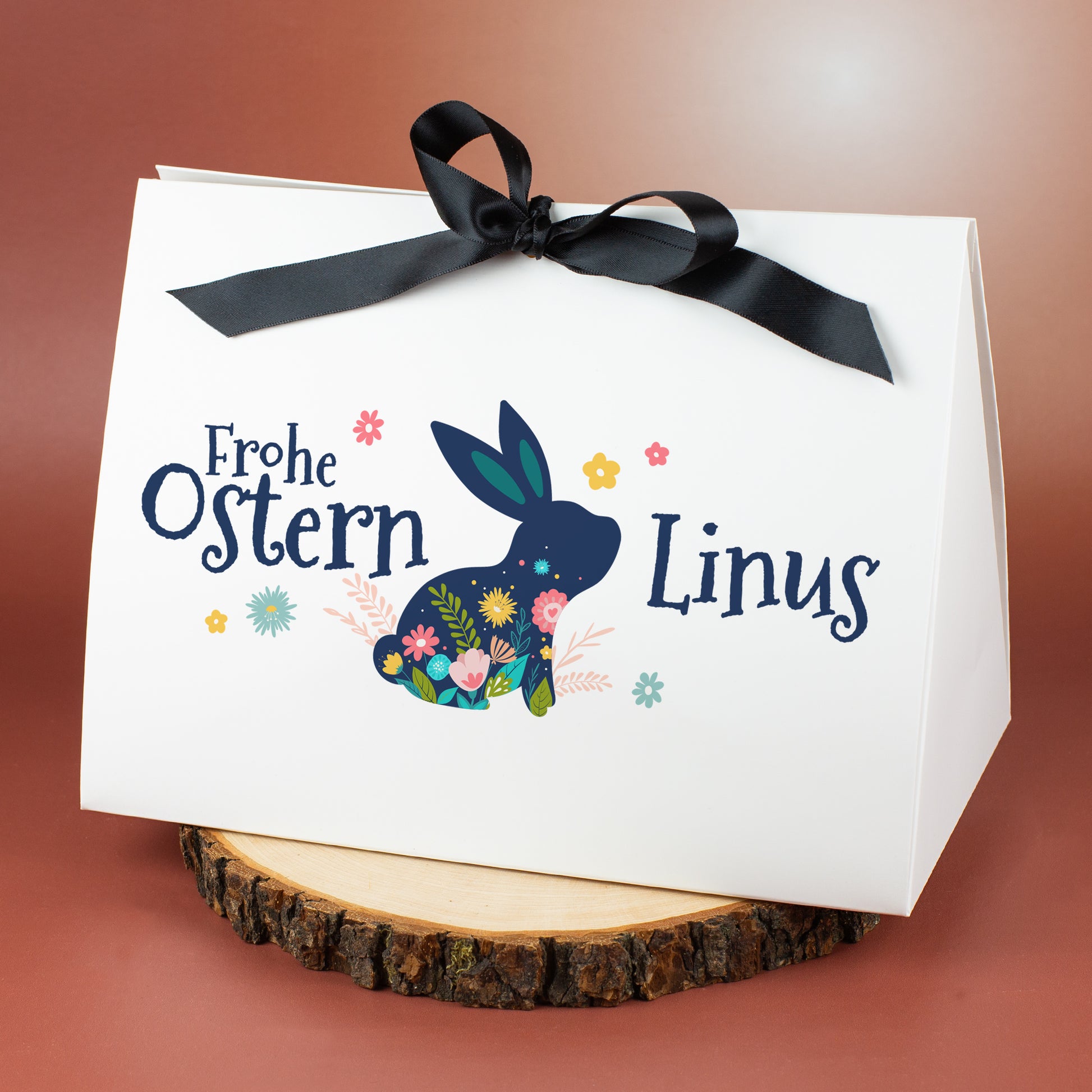 Weiße Geschenkverpackung zu Ostern mit floralem Hasenmotiv und Name Linus