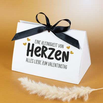 Geschenkverpackung „Eine Kleinigkeit von Herzen“ mit schwarzem Satinband und goldenen Herzchen, Vorderansicht