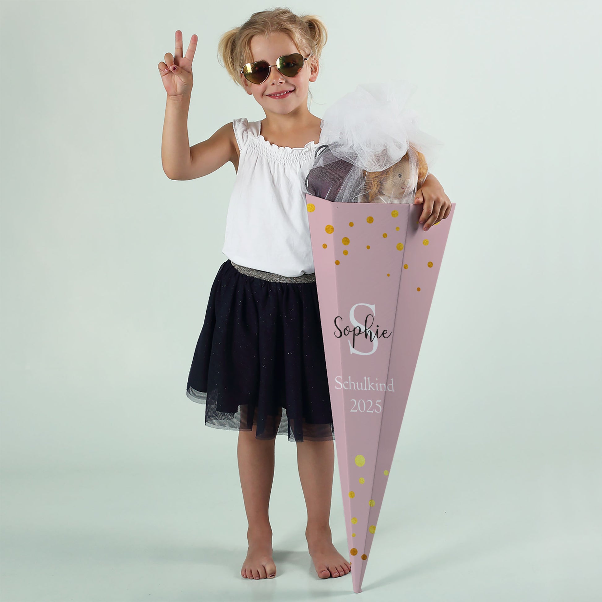 Mädchen mit rosafarbener Schultüte „Sophie“ und Aufdruck „Schulkind 2025“