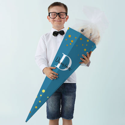 Junge mit großer Schultüte in Dunkelblau, bedruckt mit Initiale und Namen