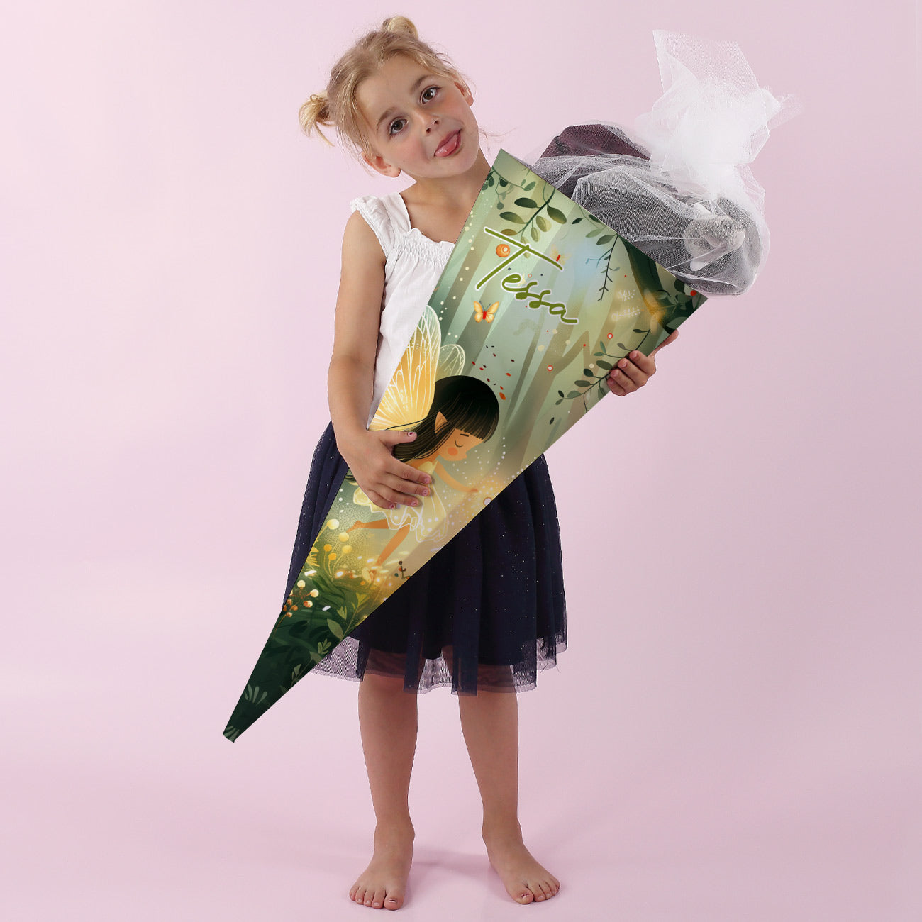 Mädchen mit dunklem Tüllrock hält eine große Zuckertüte mit Namen Tessa