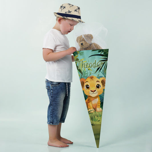 Junge in weißem T-Shirt und Strohhut betrachtet neugierig eine große Schultüte mit Löwenmotiv und Name „Theodor“.