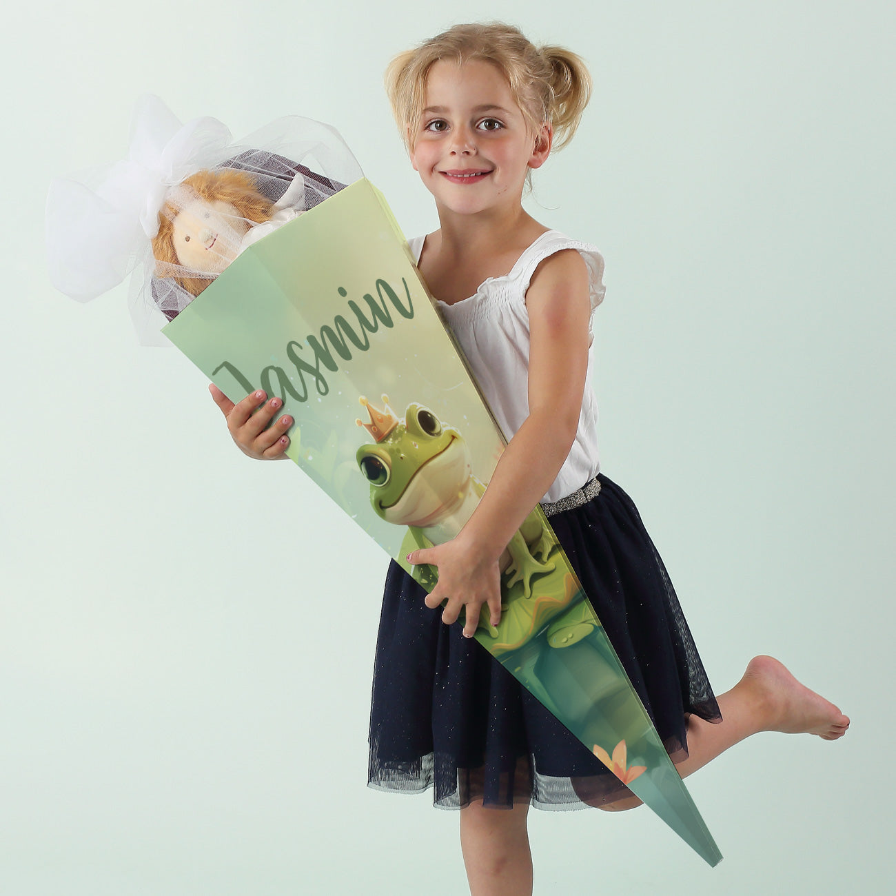 Mädchen hält eine große Zuckertüte mit Froschkönig-Motiv und dem Namen "Jasmin" in der Hand