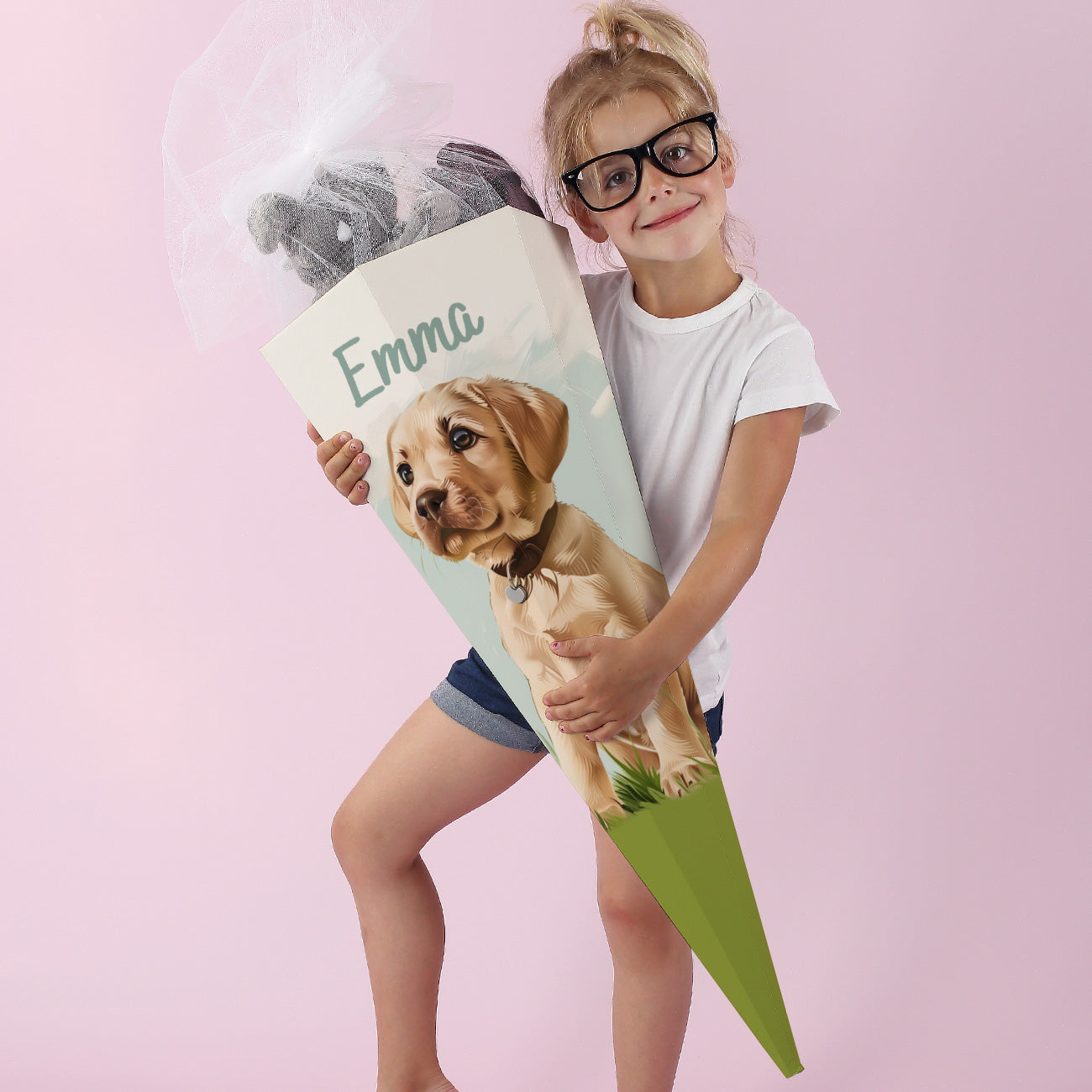 Mädchen in weißem Kleid hält liebevoll eine Hund-Schultüte mit Namensaufdruck