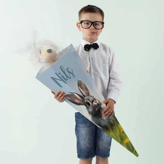 Kind mit personalisierter Schultüte mit Hasenmotiv und dem Namen „Nils“