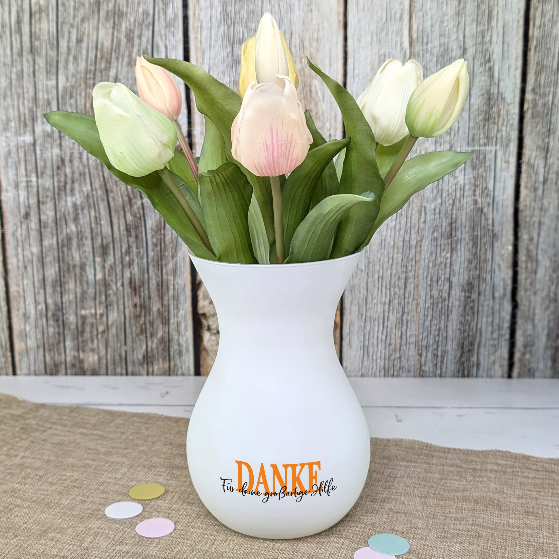 Weiße Vase mit Tulpen als stilvolle Dekoration auf Tisch platziert