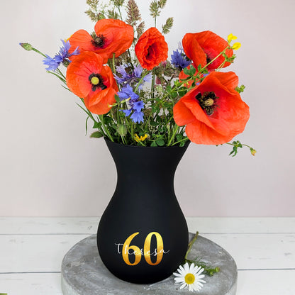 Vase in Schwarz mit Blumenstrauß – dekorativ auf Tisch platziert