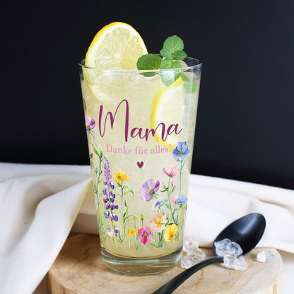 Personalisierbares Trinkglas mit Blumenmotiv und „Mama“-Schriftzug, befüllt, frontal fotografiert.