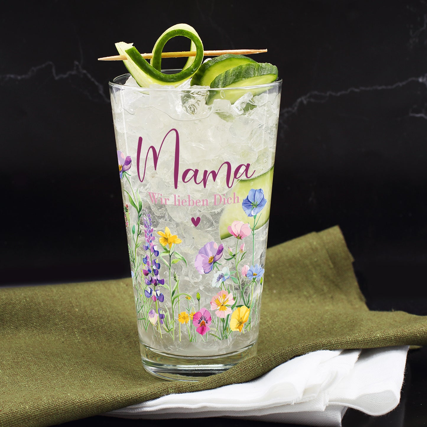 Das personalisierte Trinkglas mit dem Aufdruck „Mama“ und Blumenmotiv beim Servieren mit Dekoration.