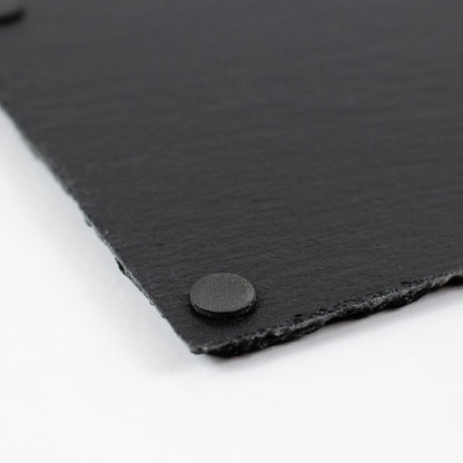 Detailaufnahme einer schwarzen Schieferplatte mit rutschfesten Pads an der Unterseite