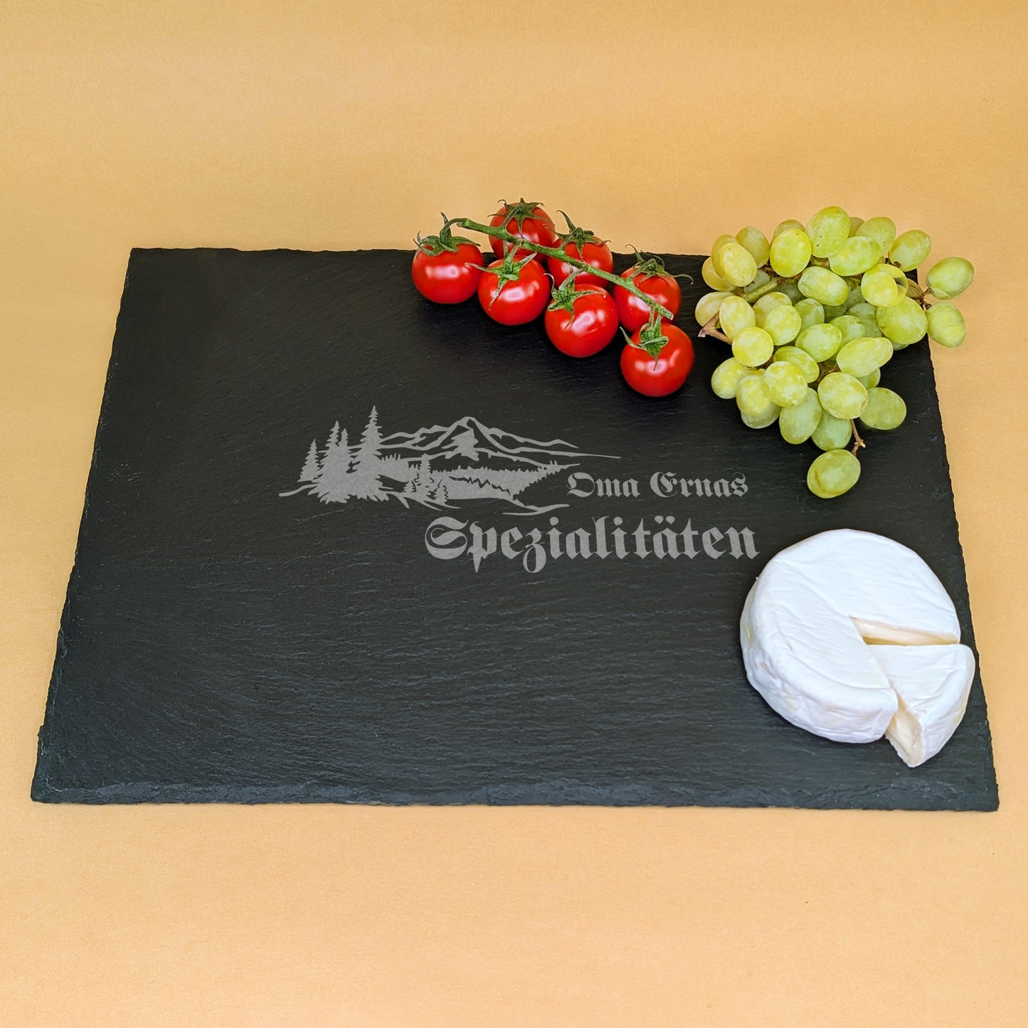 Große Servierplatte aus Schiefer mit Gravur „Oma Ernas Spezialitäten“, dekoriert mit Trauben, Käse und Tomaten