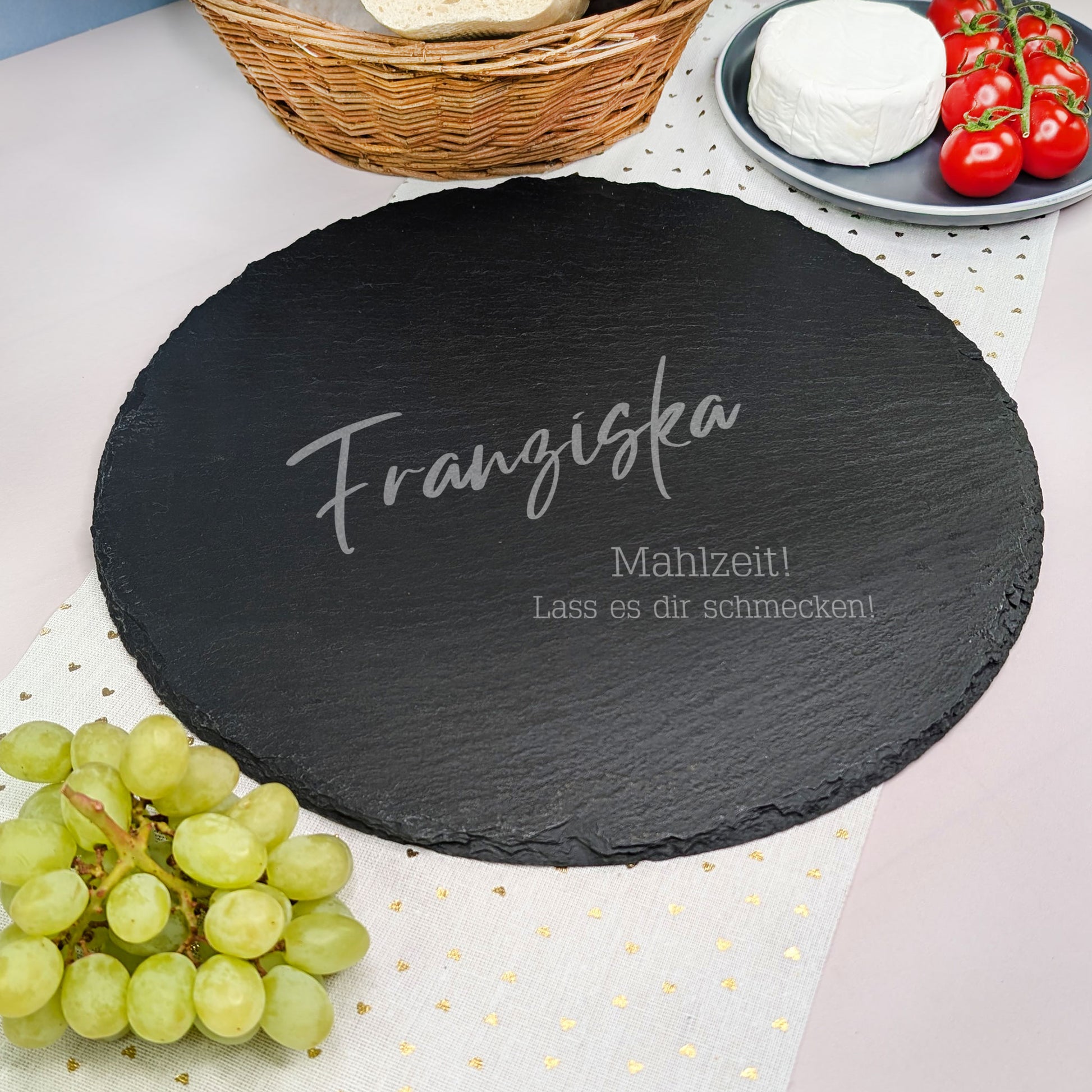 Personalisierte Schieferplatte mit Name Franziska und einem zweizeiligen Spruch, dekoriert mit Weintrauben, Tomaten, Käse und einem Baguette-Korb.