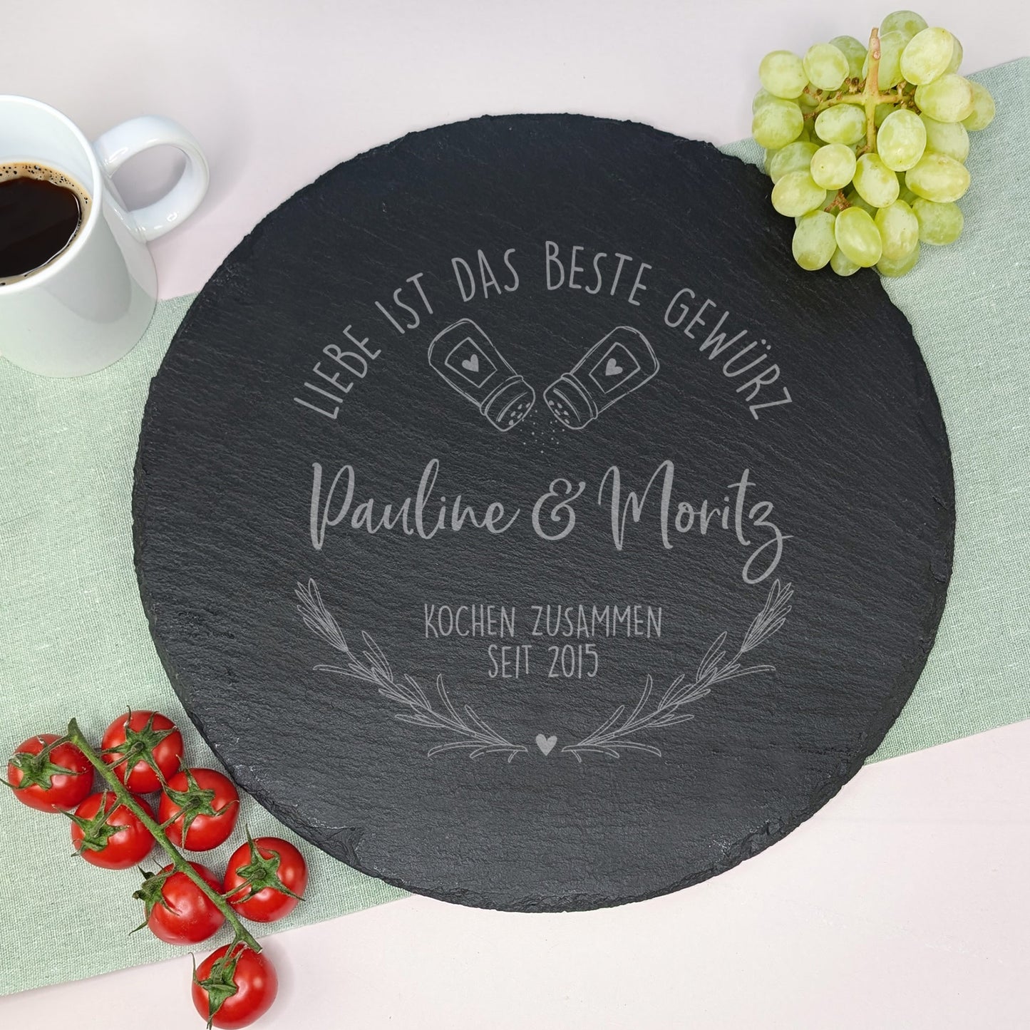 Gravierte Schieferplatte auf gedecktem Tisch mit Weintrauben, Tomaten und Kaffee – Design mit Salz- und Pfefferstreuer