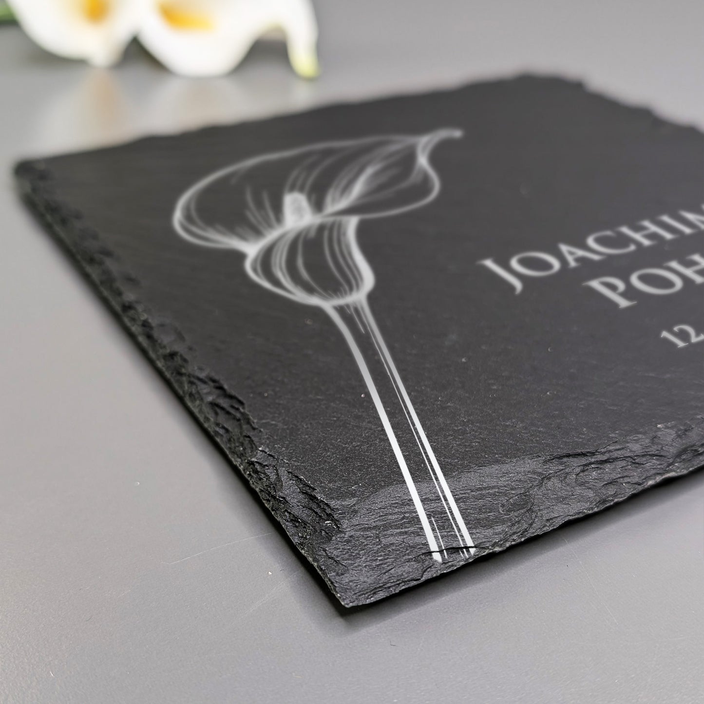 Detailaufnahme der Schiefertafel mit Calla-Motiv und persönlicher Gravur