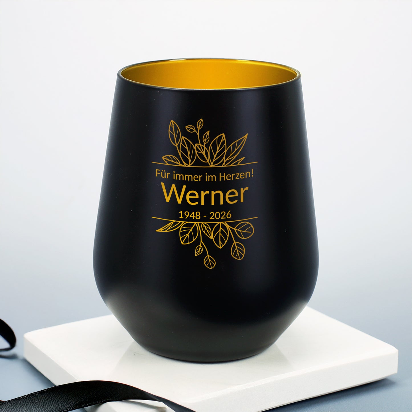 Personalisierbares Windlicht in Schwarz mit graviertem Blättermotiv, Name, Datum und Text – frontal abgebildet