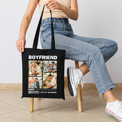 Person sitzt auf einem Stuhl und hält eine schwarze Baumwolltasche mit der Aufschrift „BOYFRIEND“ und vier individuell gestaltbaren Fotofeldern.