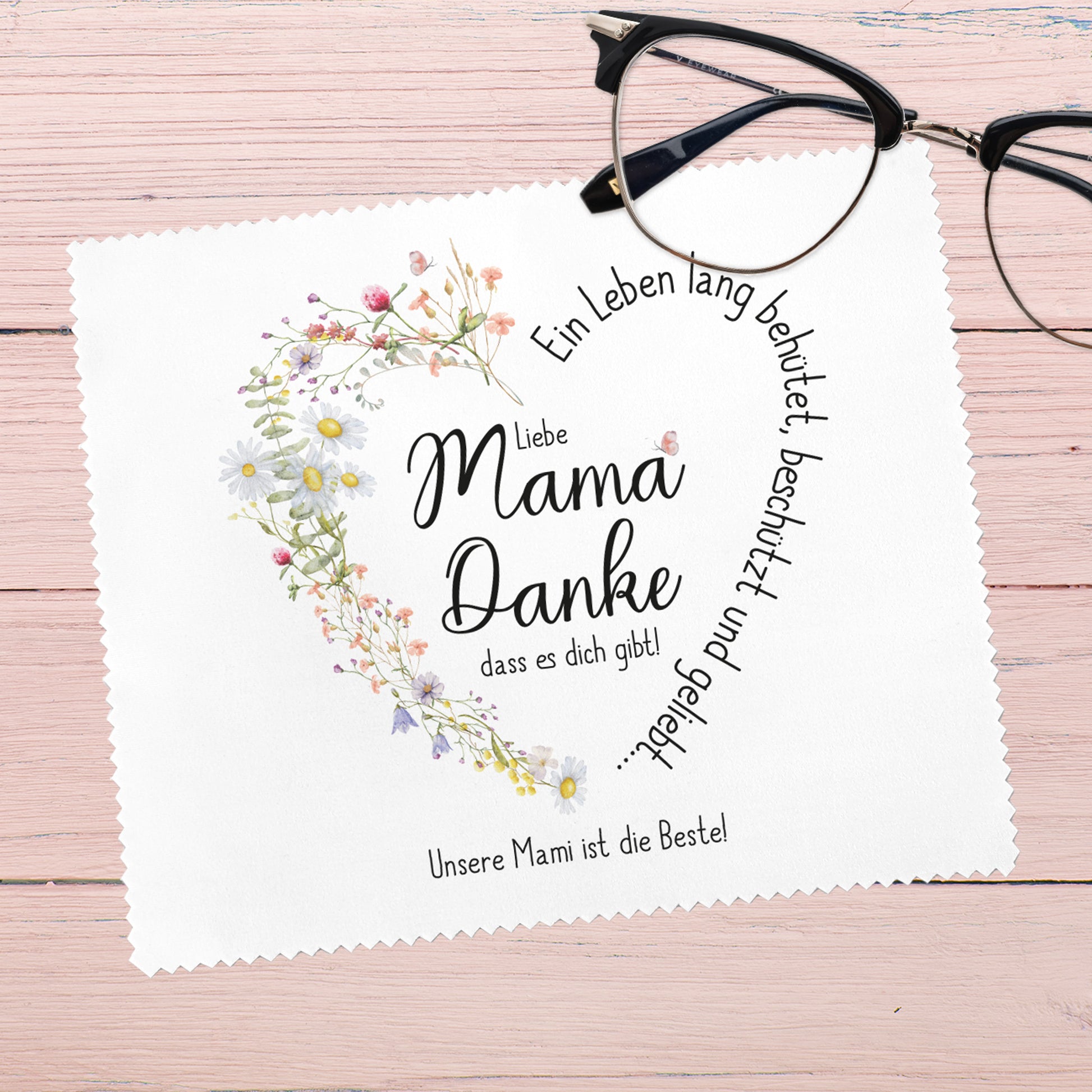Brillenputztuch für Mama mit herzförmigem Wiesenblumen-Motiv – Das weiße Reinigungstuch zeigt eine liebevolle Botschaft „Liebe Mama, Danke, dass es dich gibt!“ in Herzform, umgeben von zarten Blüten. Eine wunderbare Geschenkidee zum Muttertag oder als persönliche Aufmerksamkeit.