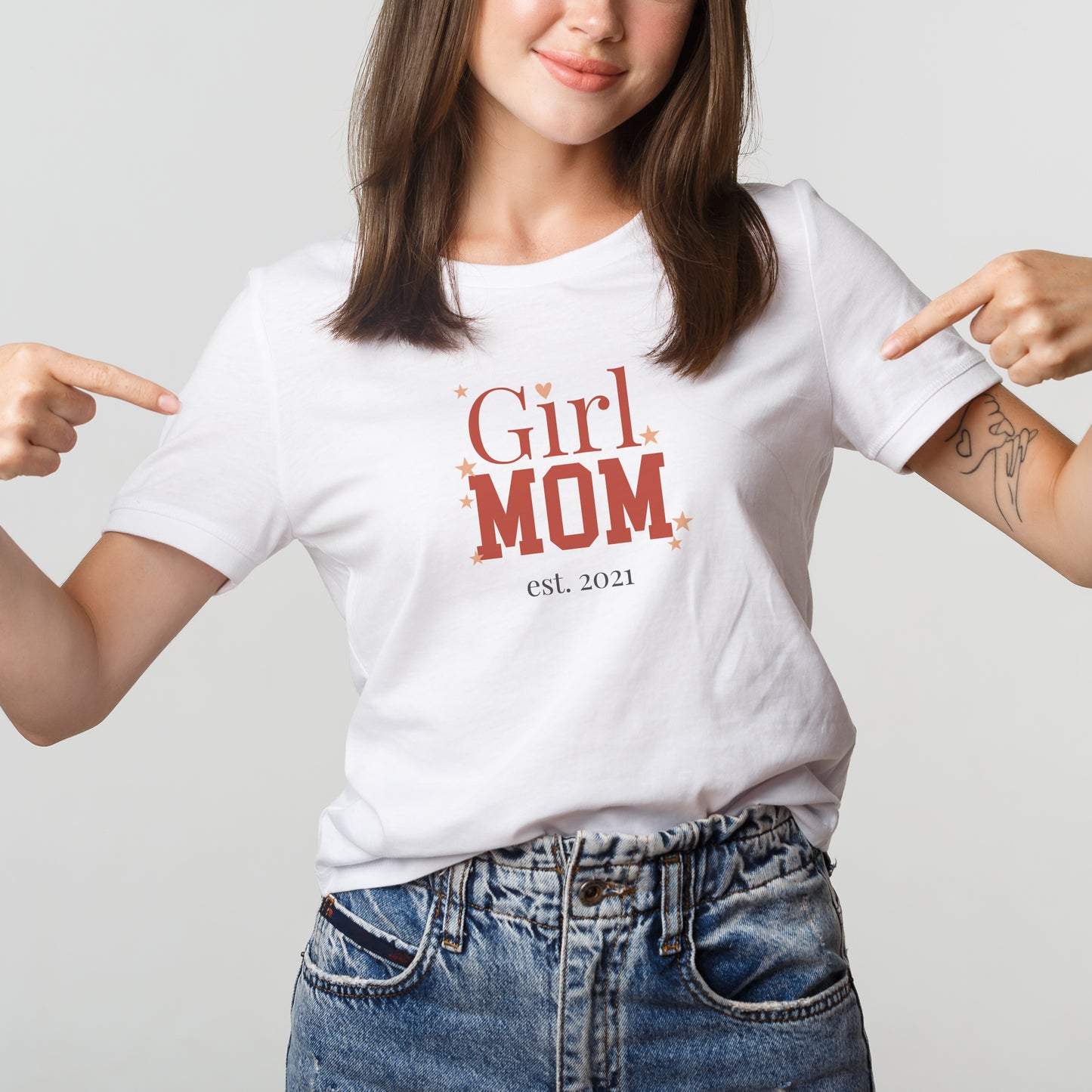 Frau trägt weißes „Girl Mom“ T-Shirt und zeigt auf den personalisierten Aufdruck