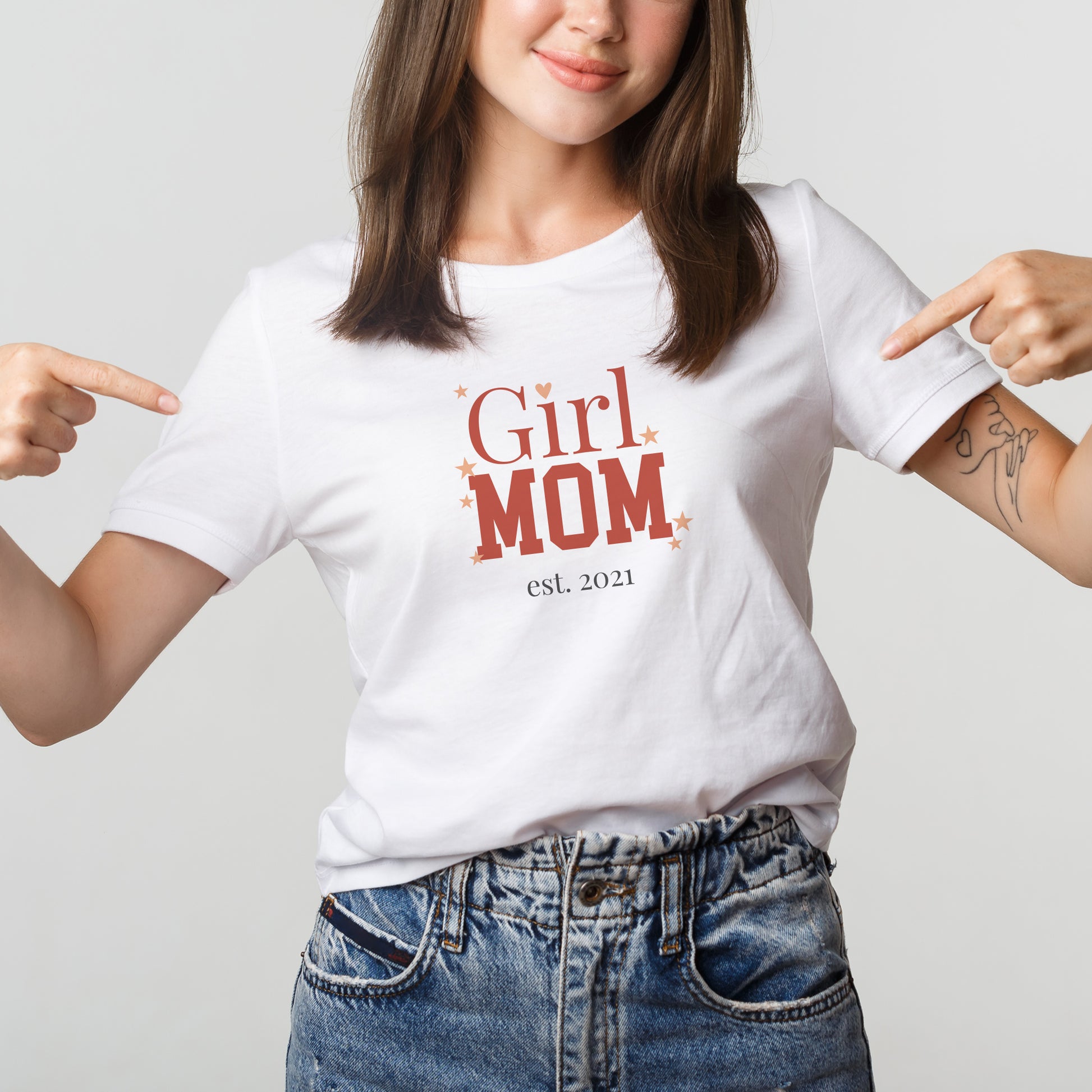 Frau trägt weißes „Girl Mom“ T-Shirt und zeigt auf den personalisierten Aufdruck