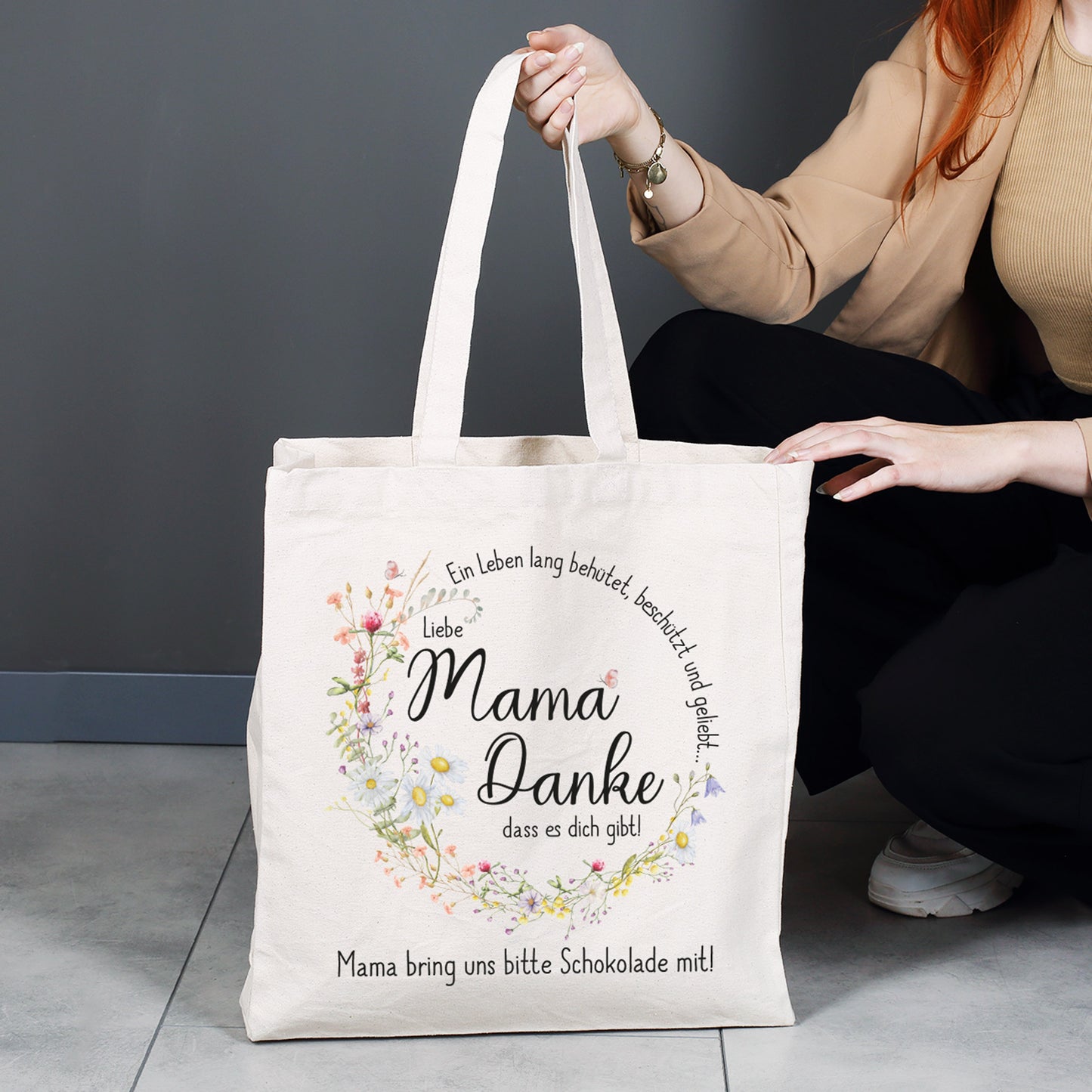 Großer Baumwollbeutel für den Alltag – Shopper mit liebevollem Mama-Spruch und floralem Design, gehalten von einer Person, ideal für Einkäufe und Besorgungen.