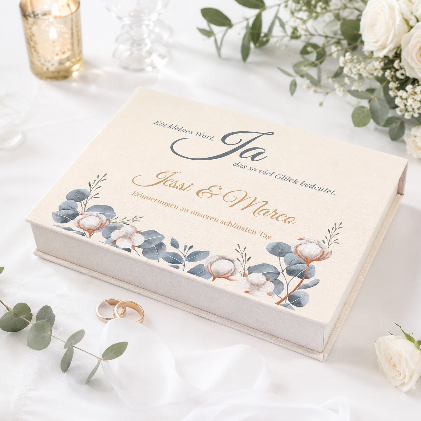 Personalisierte Erinnerungsbox zur Hochzeit mit Eukalyptus-Motiv, Baumwollblüten, Namen und Wunschtext auf festlich gedecktem Tisch