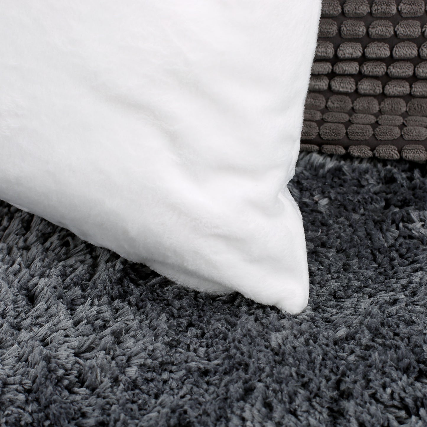 Detailaufnahme der Rückseite eines weißen Kissens, das eine flauschige Oberfläche zeigt. Perfekt als Dekokissen oder Kuschelkissen.